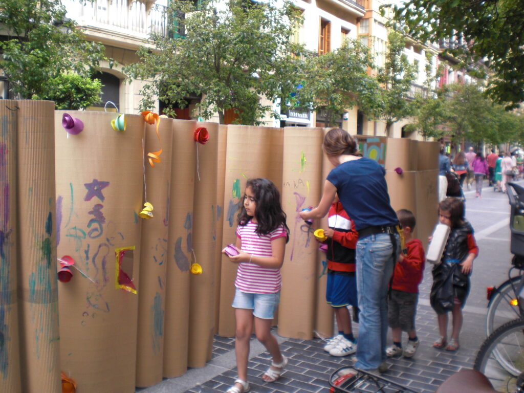 Paneles de cartón instalados en la calle con niños participando