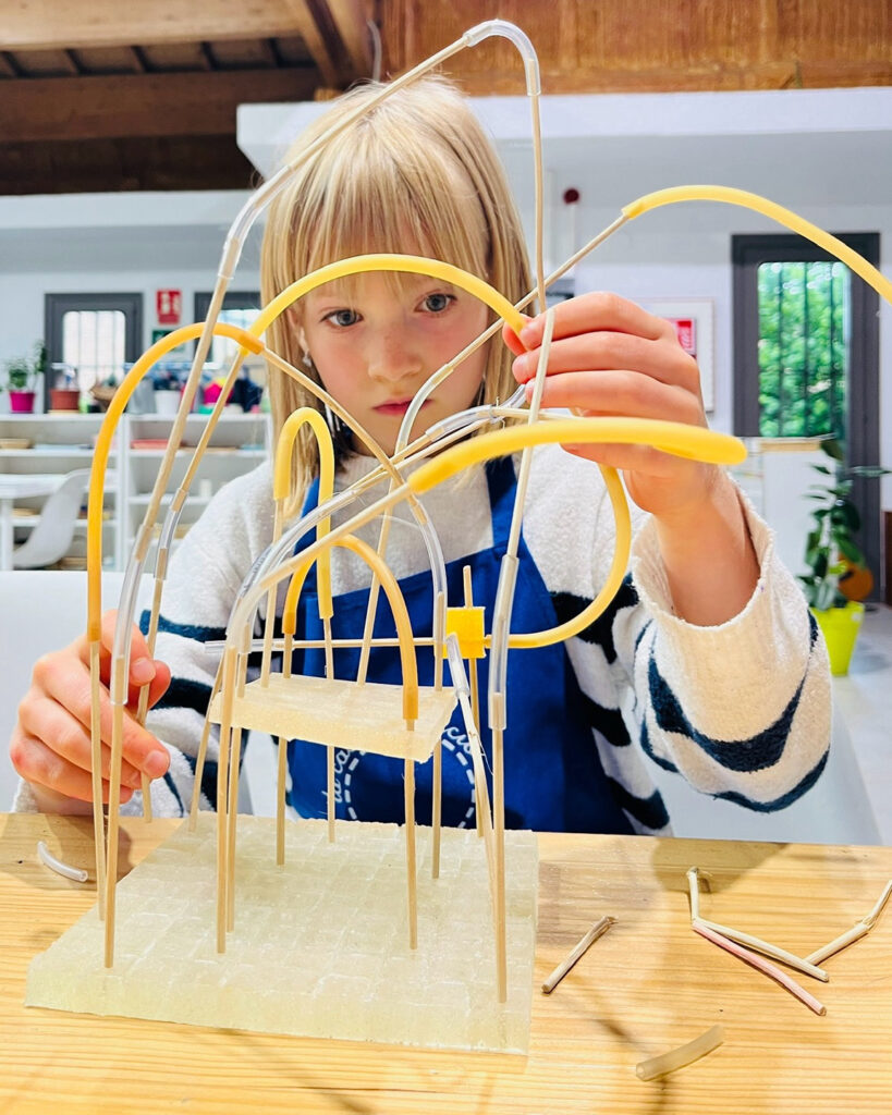 Niño construyendo una estructura con varillas del juego de construcción Pi
