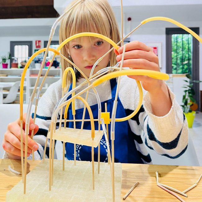 Niño construyendo una estructura con varillas del juego de construcción Pi