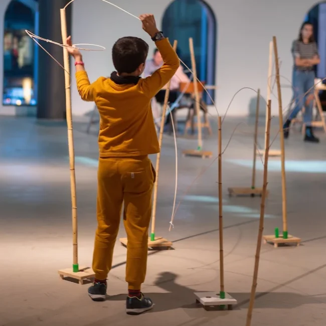 Niño construyendo una estructura con un kit de materiales naturales