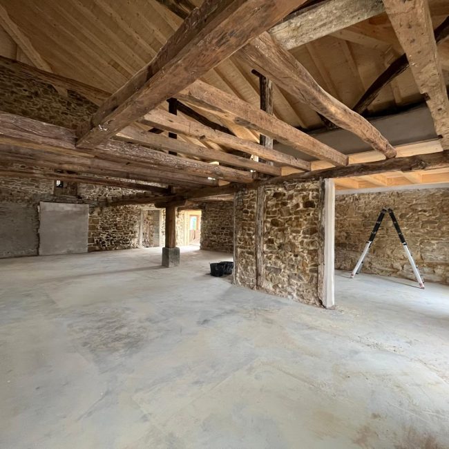 Interior de piedra y vigas de madera de la nueva sede en rehabilitación